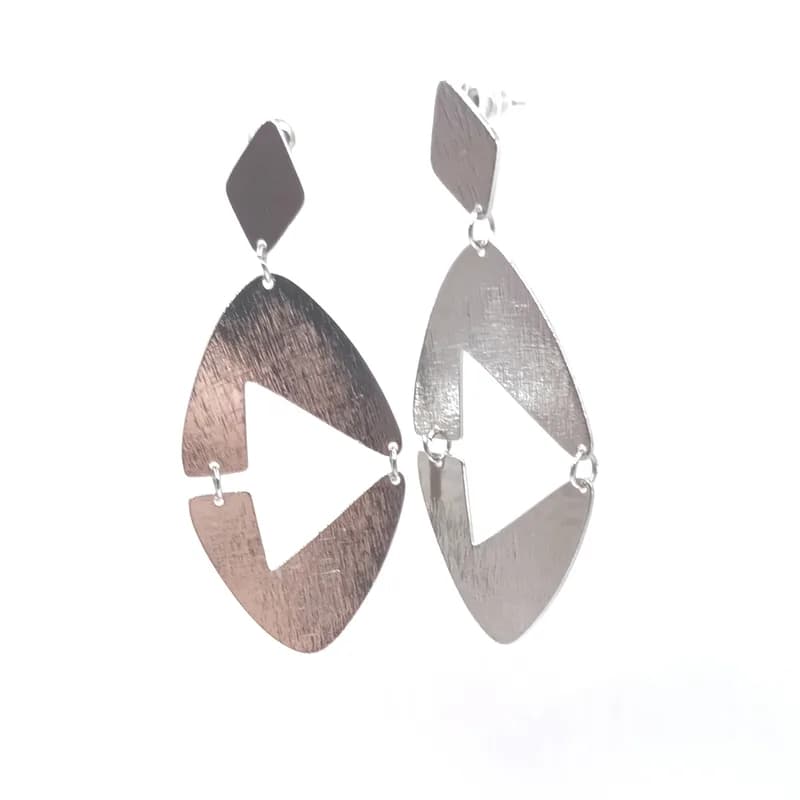 Paire de boucles d'oreilles pendantes géométriques ton argenté, vue de trois quarts.